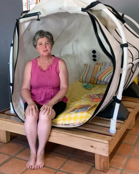 Julia seated at the entrance of the mild HBoT chamber