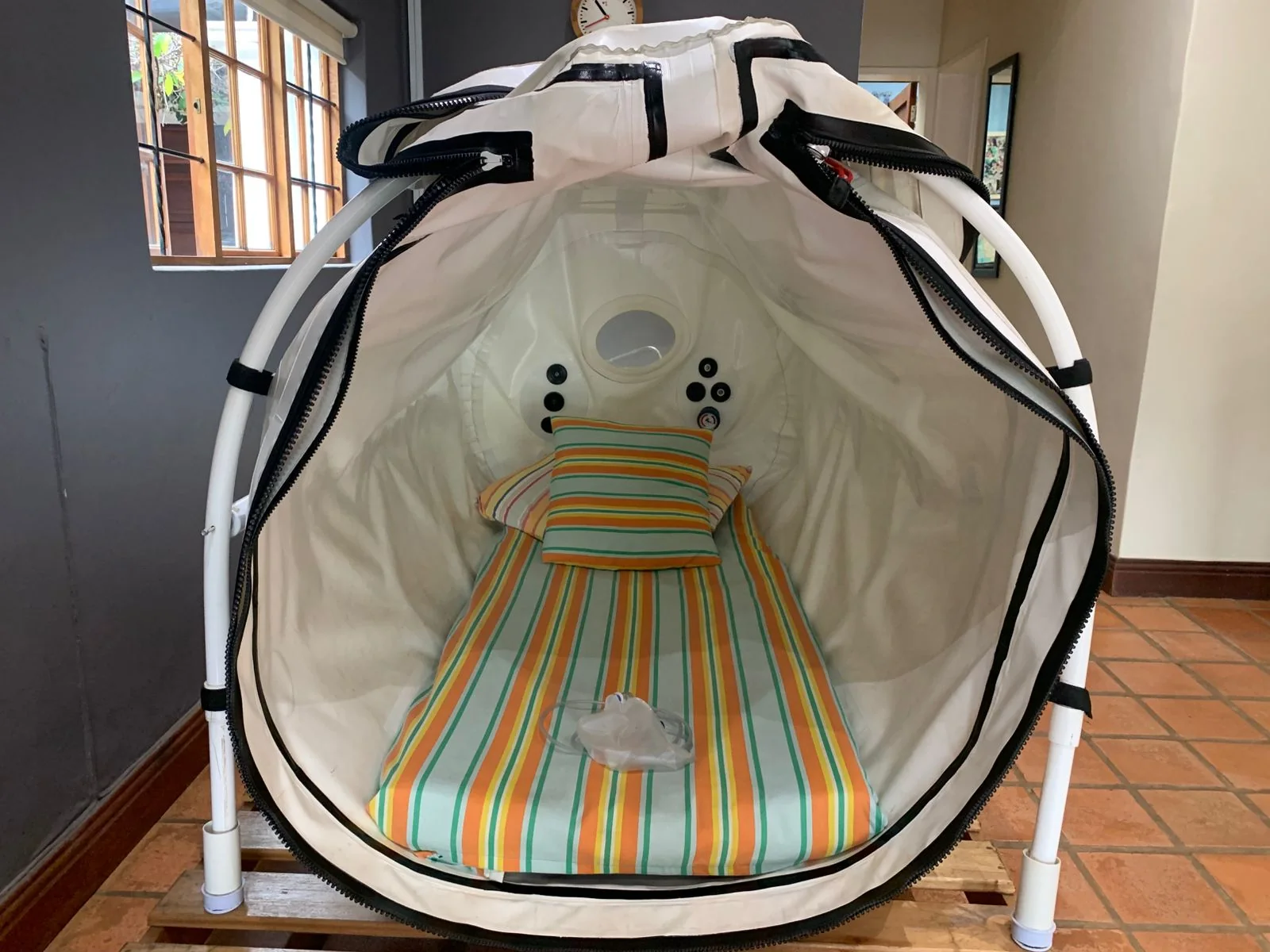 Open mild HBoT chamber prepared with striped bedding and pillows
